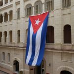 Two-story tall Cuban flag hanging on the side of a building
