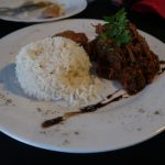 A pile of white rice and shredded beef on a white plate