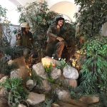 Life-size figures of Che Guevara and Fidel Castro in a diorama with rocks, trees, and greenery