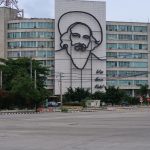 Building with a metal outline image of Camilo Cienfuegos on it and the words "Vas bien Fidel."